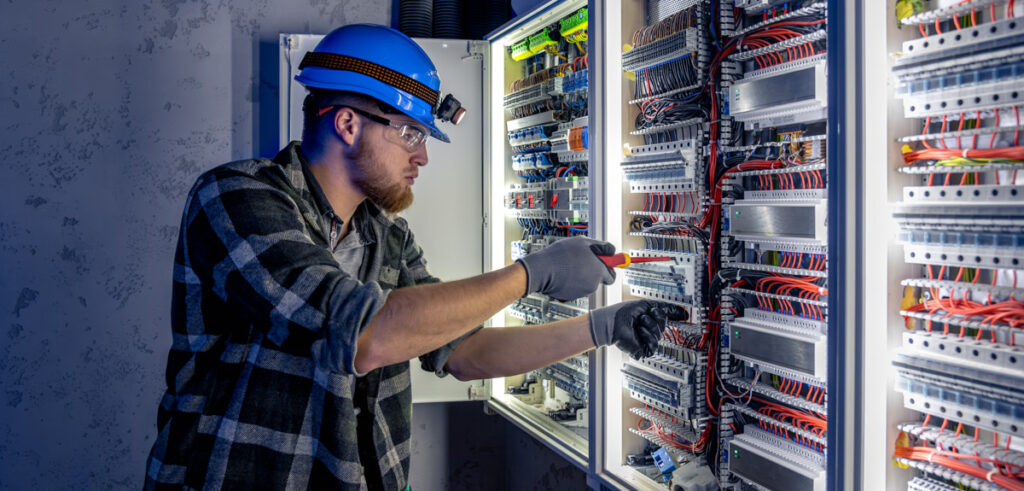 Techniker arbeitet an Schaltschrank.